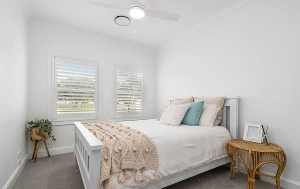 A Bedroom with A Bed, Nightstand, and Ceiling Fan | Mid-North Coast, NSW | BDM Constructions