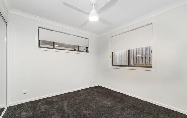 An Empty Bedroom with A Ceiling Fan and Two Windows | Mid-North Coast, NSW | BDM Constructions