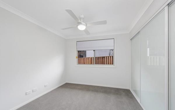 An Empty Bedroom with A Ceiling Fan and Sliding Glass Doors | Mid-North Coast, NSW | BDM Constructions
