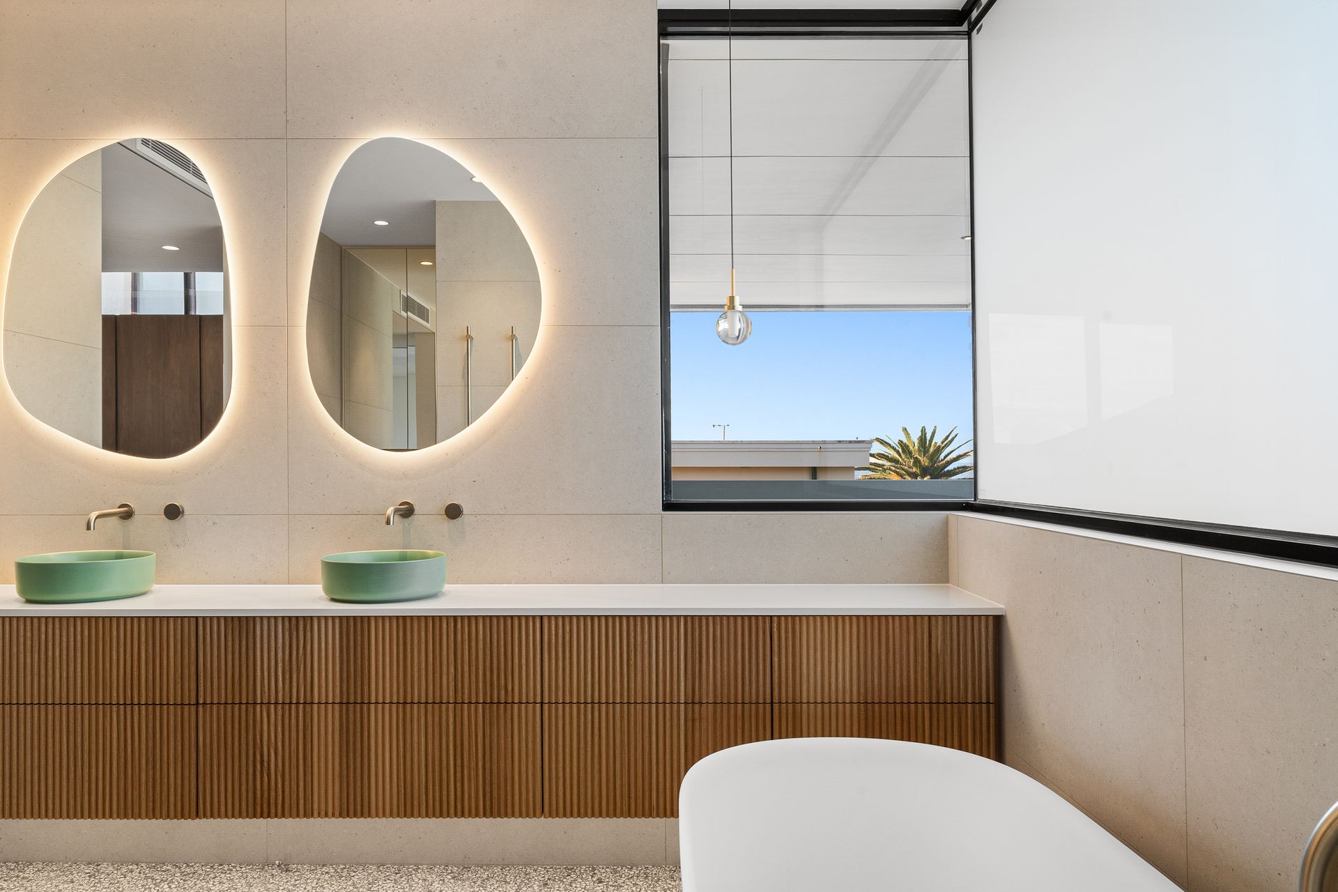 A bathroom with two sinks , two mirrors and a tub.