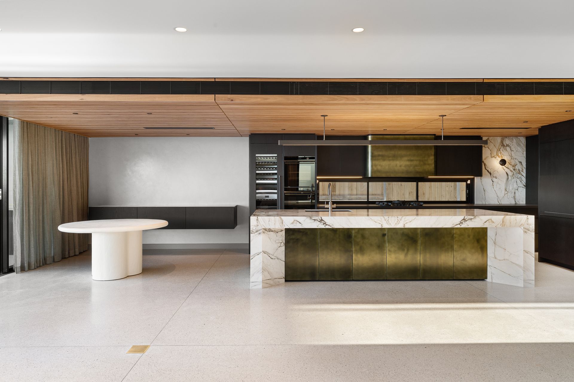 A kitchen with a large island and a table in the middle of the room.