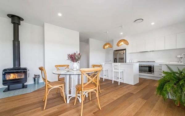 A Dining Room with A Table and Chairs and A Fireplace | Mid-North Coast, NSW | BDM Constructions