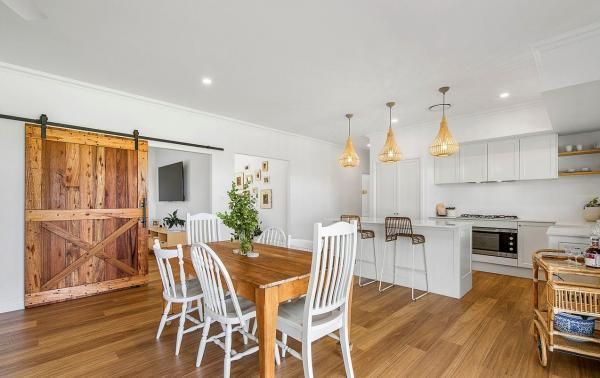 A Dining Room with A Wooden Table and Chairs and A Sliding Barn Door | Mid-North Coast, NSW | BDM Constructions