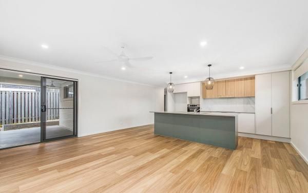 A Living Room with Hardwood Floors and A Kitchen in The Background | Mid-North Coast, NSW | BDM Constructions