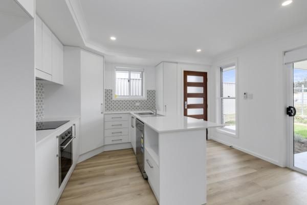 A Kitchen with White Cabinets , Stainless Steel Appliances, and A Large Island | Mid-North Coast, NSW | BDM Constructions