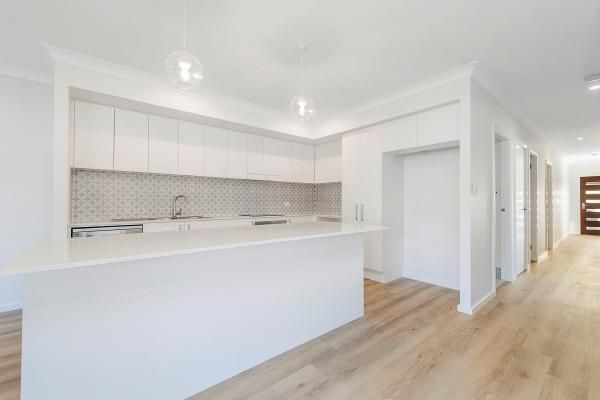 A Kitchen with White Cabinets and Wooden Floors in A House | Mid-North Coast, NSW | BDM Constructions