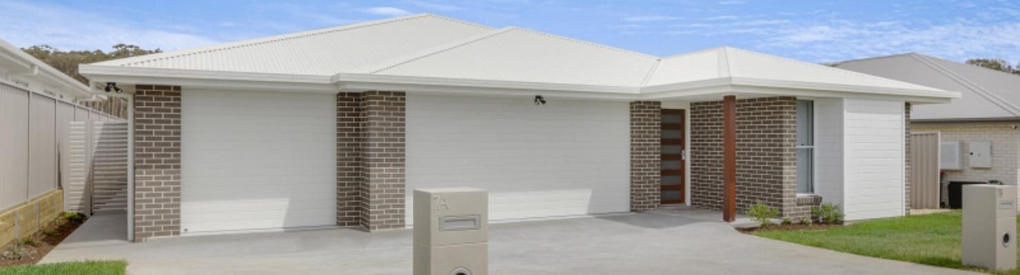 A White House with A Brick Wall and A Driveway in Front of It | Mid-North Coast, NSW | BDM Constructions