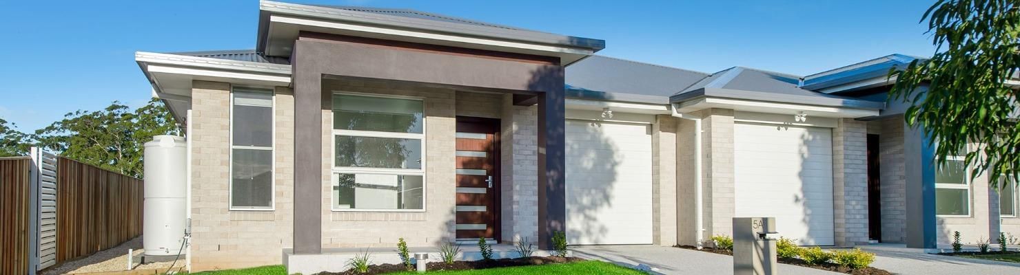 A White House with A Gray Roof Is Sitting on Top of A Lush Green Lawn | Mid-North Coast, NSW | BDM C