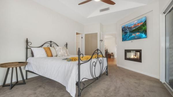 A Bedroom with A Bed, Ceiling Fan, Television and Fireplace | Mid-North Coast, NSW | BDM Constructions