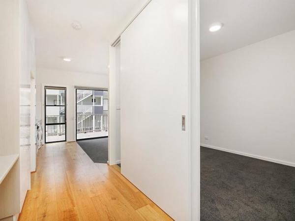 A Hallway with Wooden Floors and Sliding Doors Leading to A Bedroom | Mid-North Coast, NSW | BDM Constructions