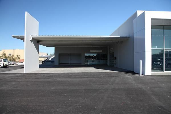 A White Building with Cars Parked in Front of It | Mid-North Coast, NSW | BDM Constructions
