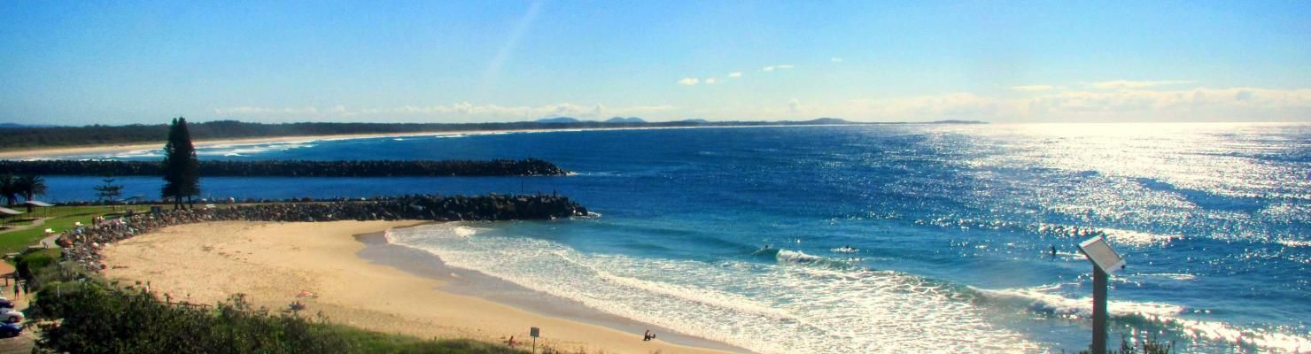 A Blurry Picture of A Beach and Ocean with A Lighthouse in The Distance | Mid-North Coast, NSW | BDM