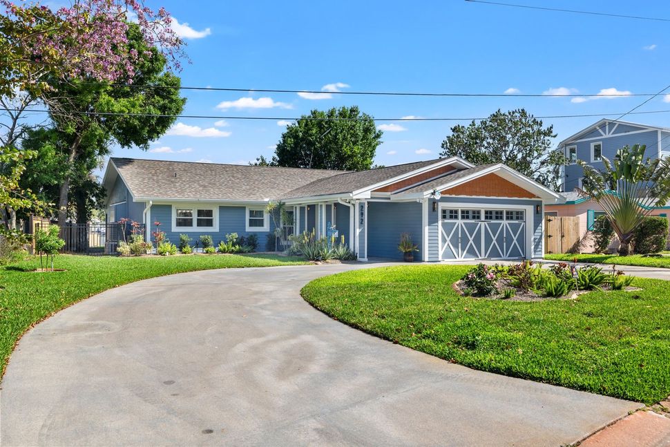 St. Petersburg rental home with For Rent sign on a sunny palm-lined street