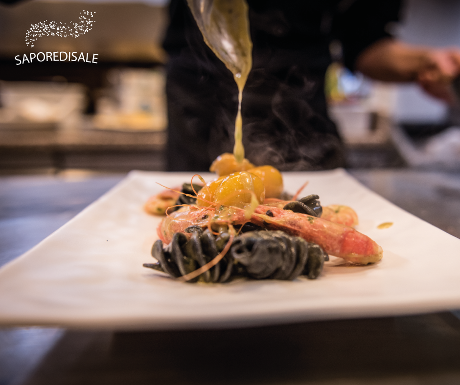 Piatto di pasta con gamberi, condito con salsa in un ristorante.
