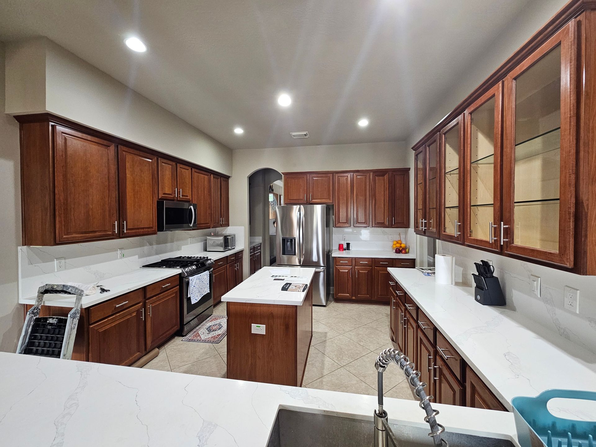 A car is parked in a garage next to a kitchen.