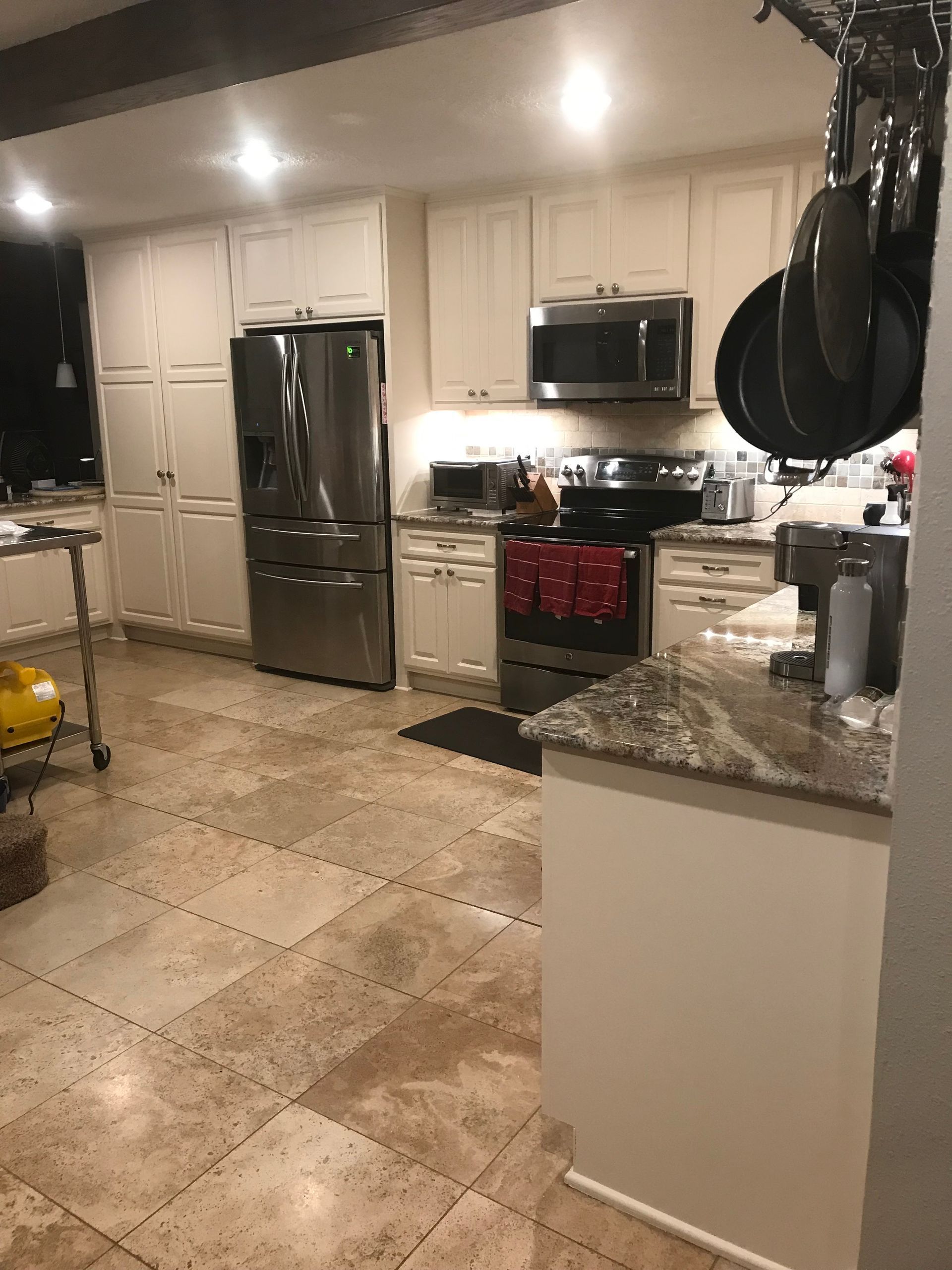 A kitchen with white cabinets and green walls is being remodeled.