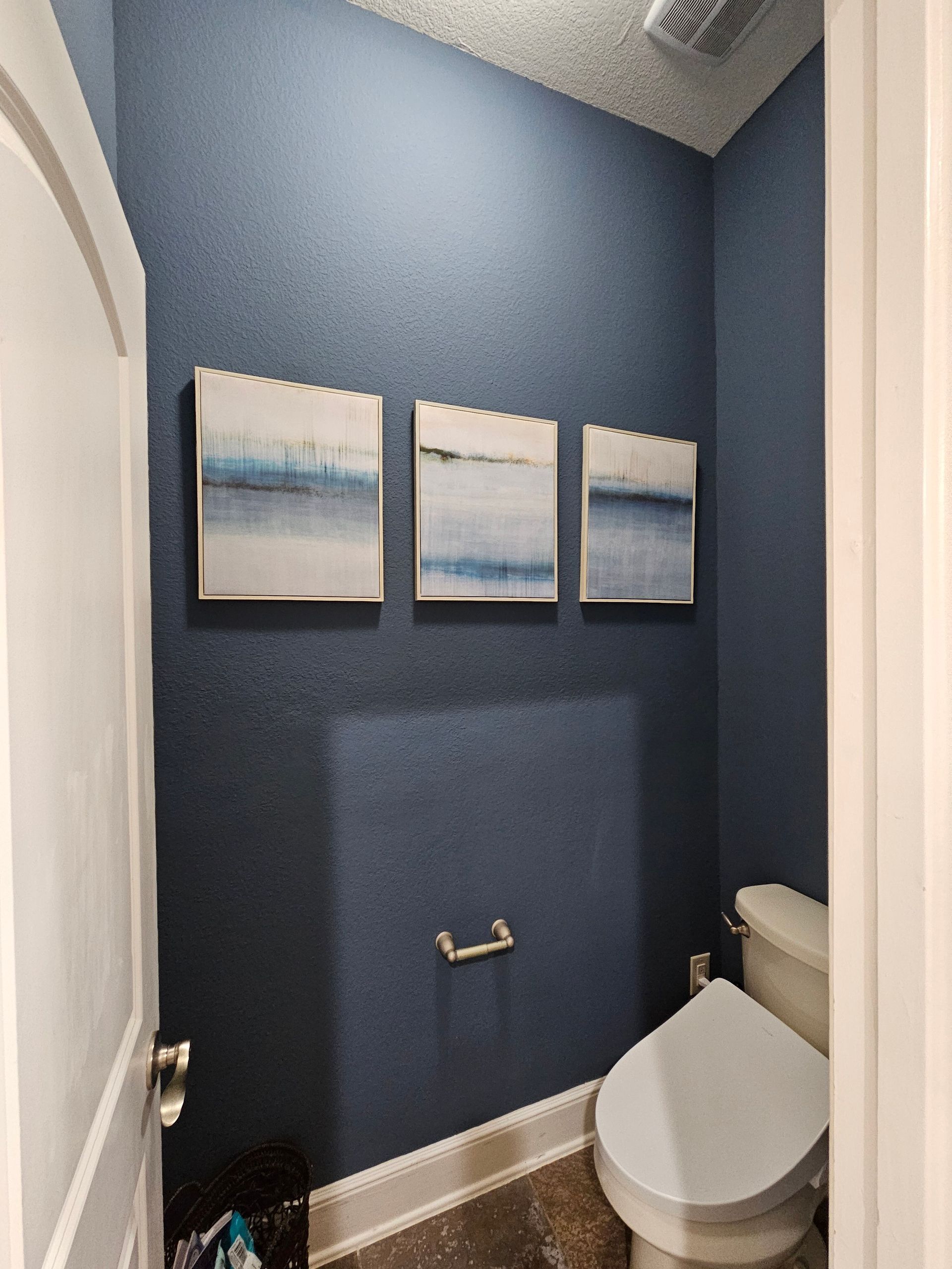The front door of a house is painted blue and has a black frame.
