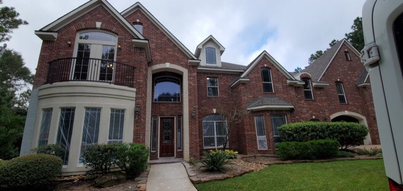A large brick house with a white van parked in front of it.