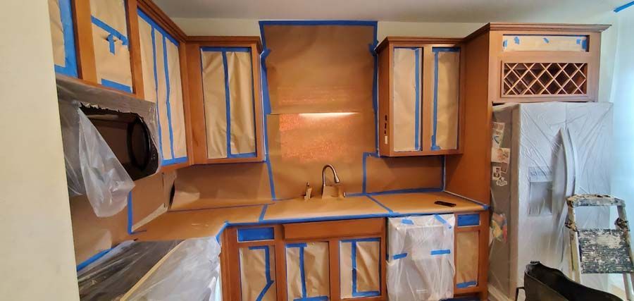 A kitchen with a lot of cabinets and appliances and a tiled floor.