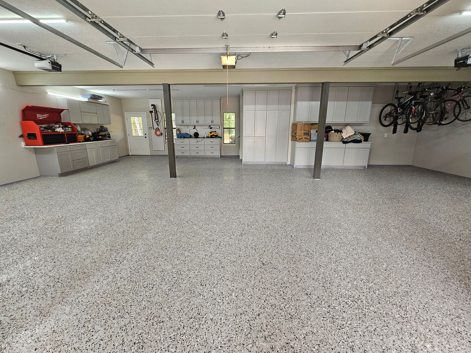 A large garage with bikes hanging from the ceiling.