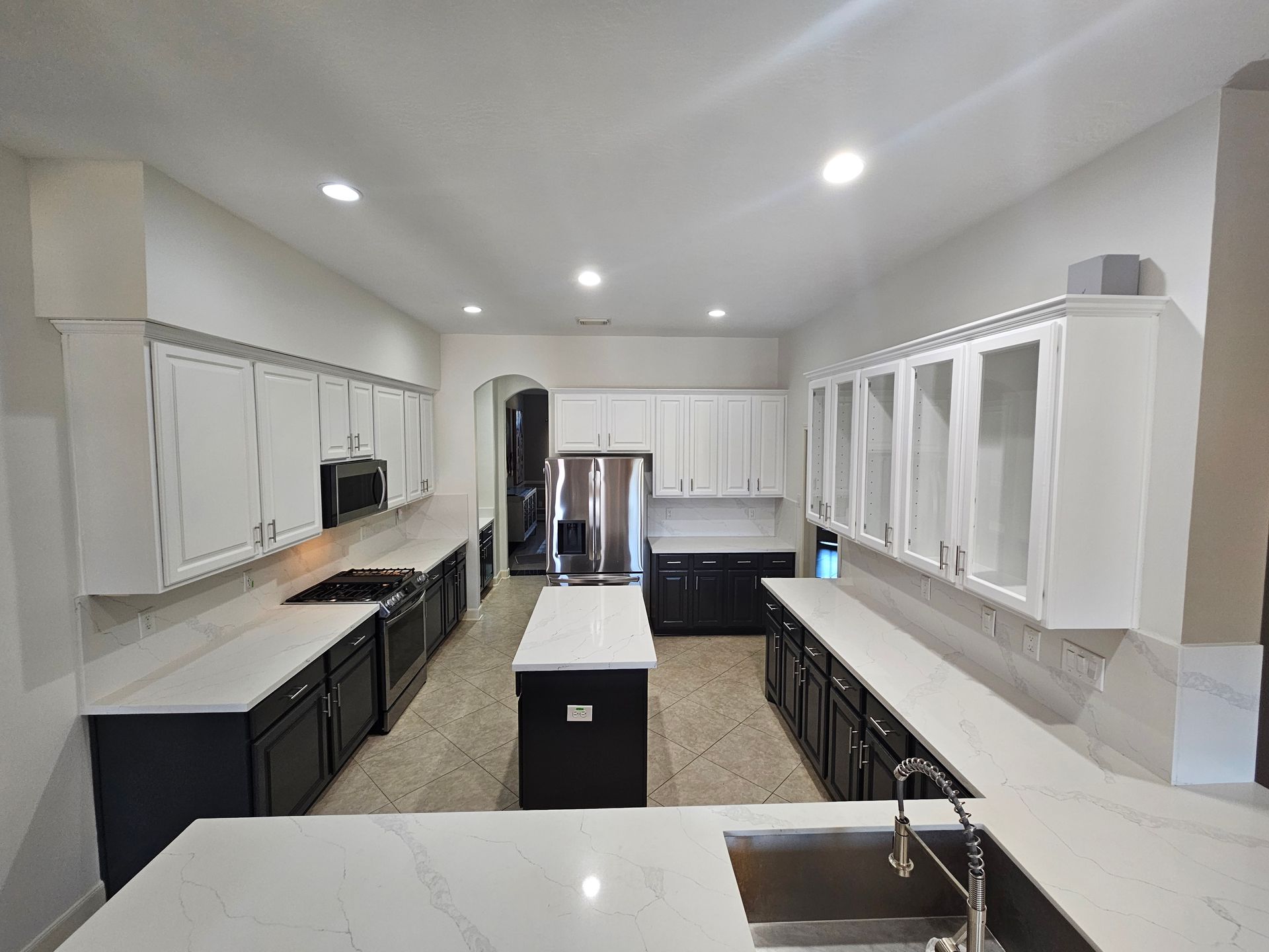 A large empty room with a gray floor and white cabinets.