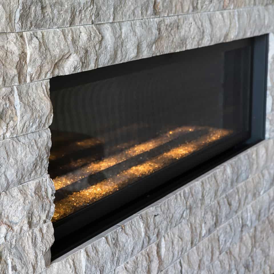 Fireplace with glowing embers and stone surround.