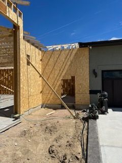 Construction site: wooden walls, blue sky, outdoor setting.