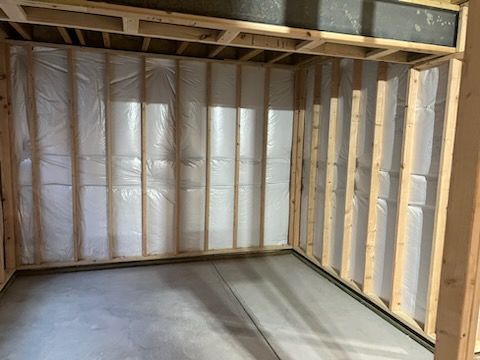 Interior room framing with insulation and vapor barrier, ready for drywall.