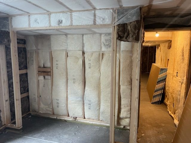 Framed wall with insulation installed in a basement under construction.