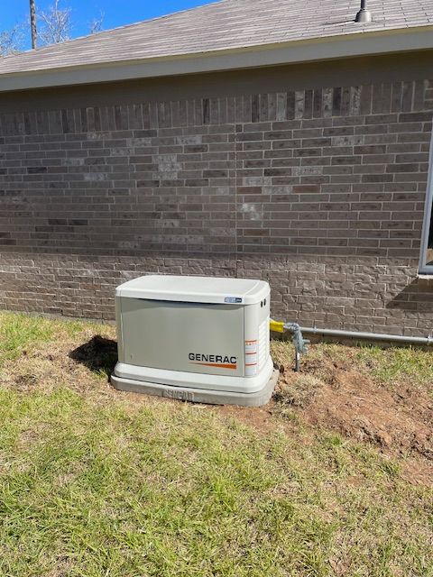 Generator unit next to a brick building.