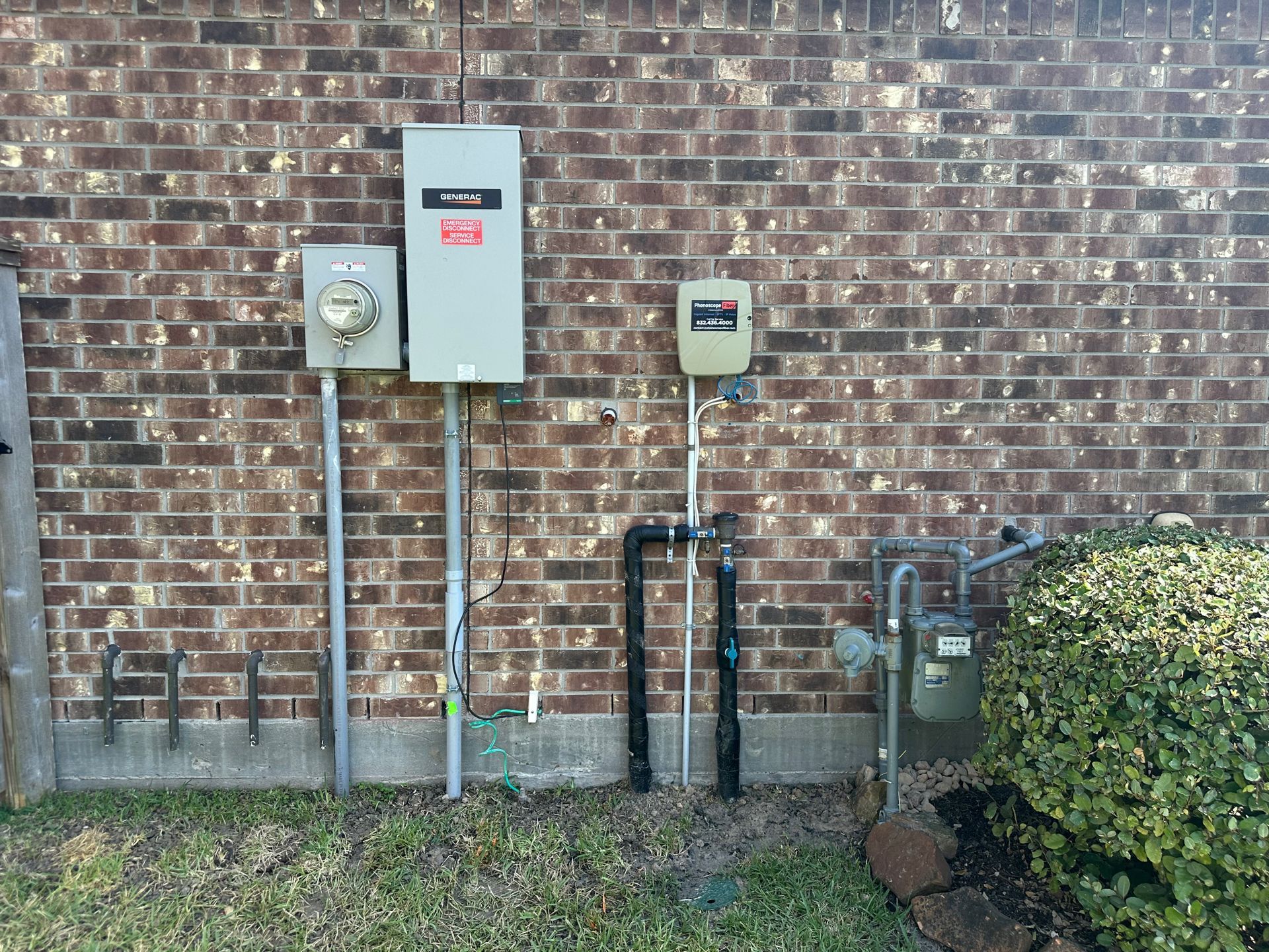 Electrical meters and gas meter mounted on a brick wall.
