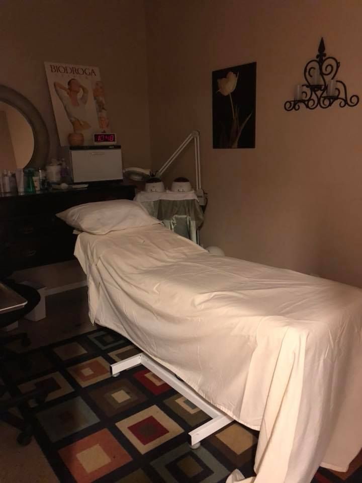 A massage table in a room with a kenwood poster on the wall