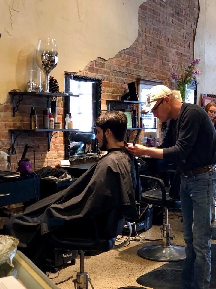 A man is getting his hair cut at a barber shop