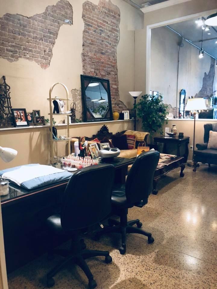 A living room with a brick wall and a desk and chairs