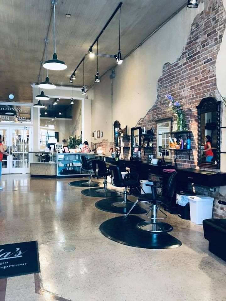 A hair salon with a brick wall and a lot of chairs