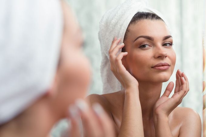Horizontal image of a self-confident brunette looking at her reflection.