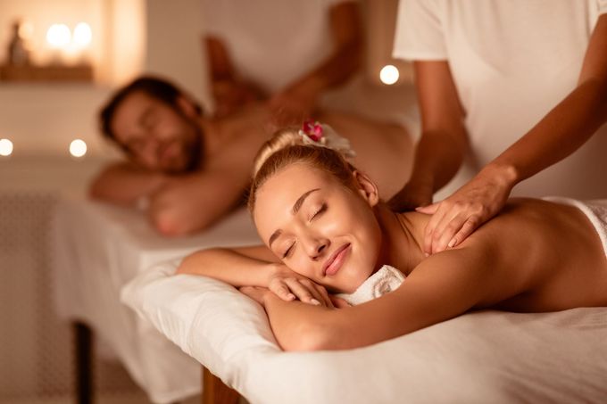 A man and a woman are getting a massage at a spa.