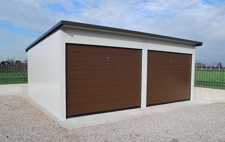 un garage con due porte scorrevoli marroni e un tetto bianco .