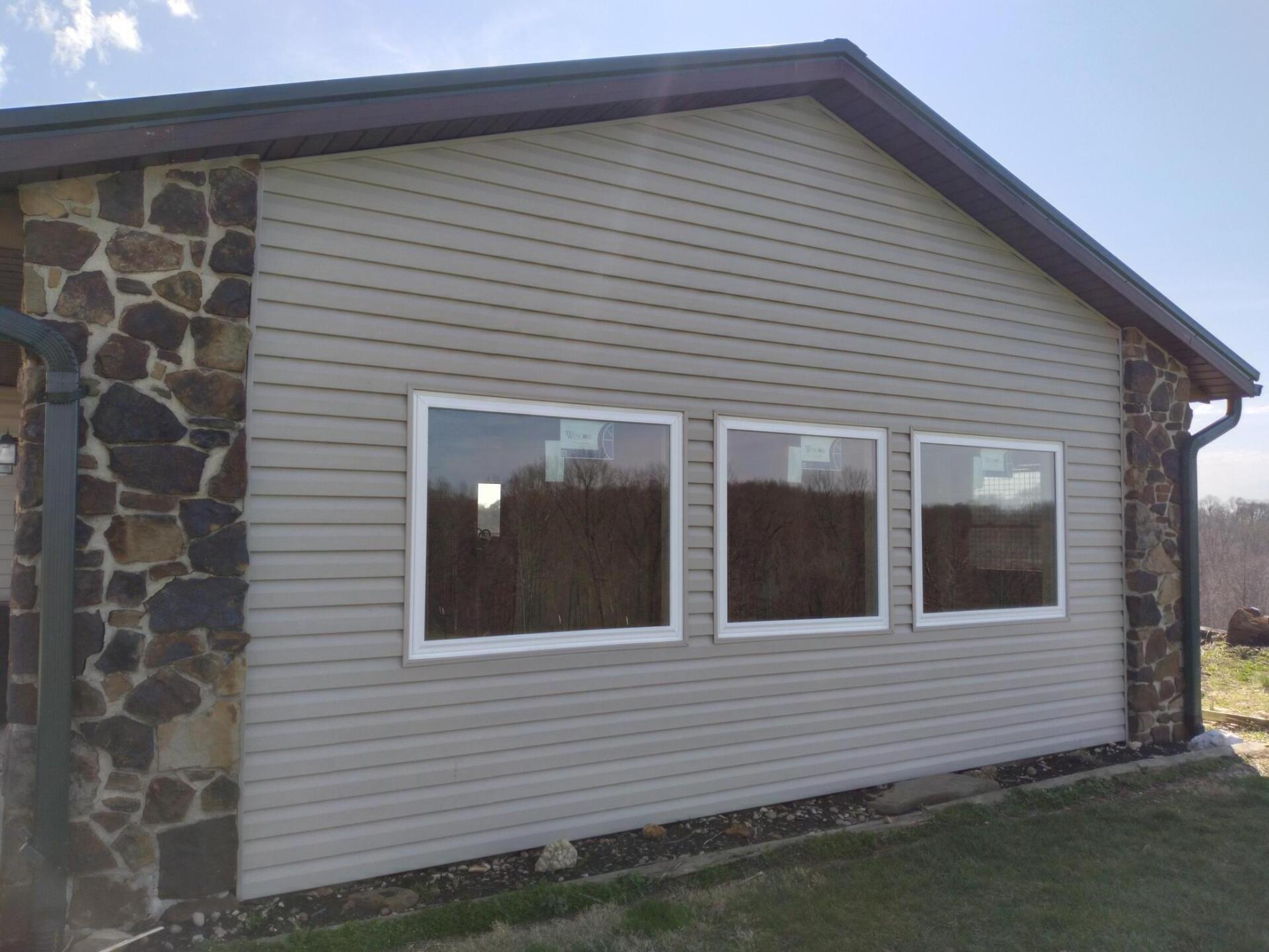 A house with three windows on the side of it