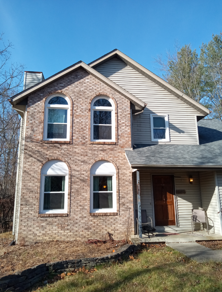 A large brick house with arched windows and a gray roof