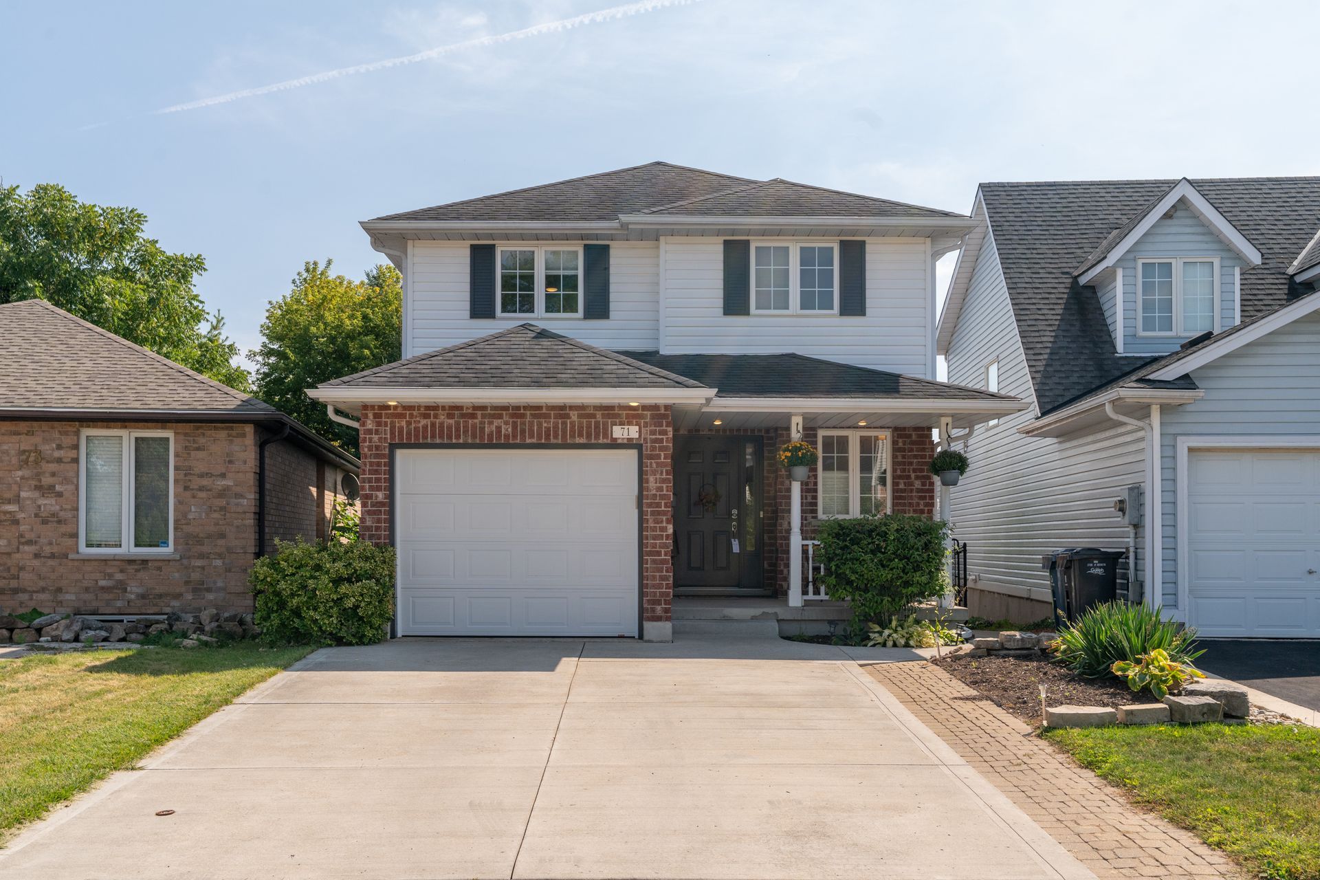 Suburban two-story house with brick facade, garage, and driveway in front