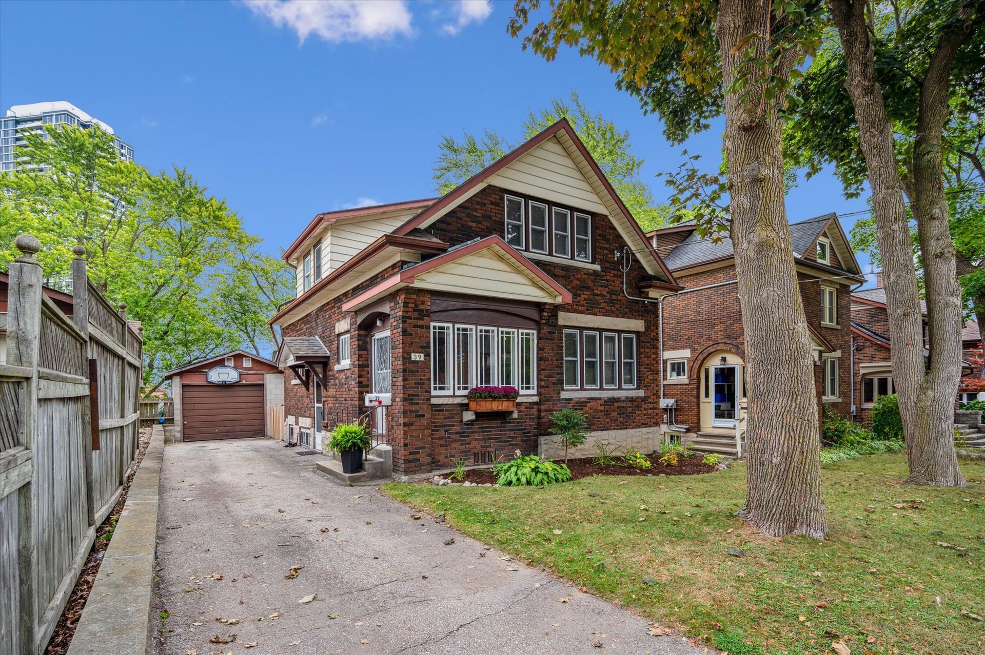 Brick house with a driveway, garage, and front yard under a blue sky