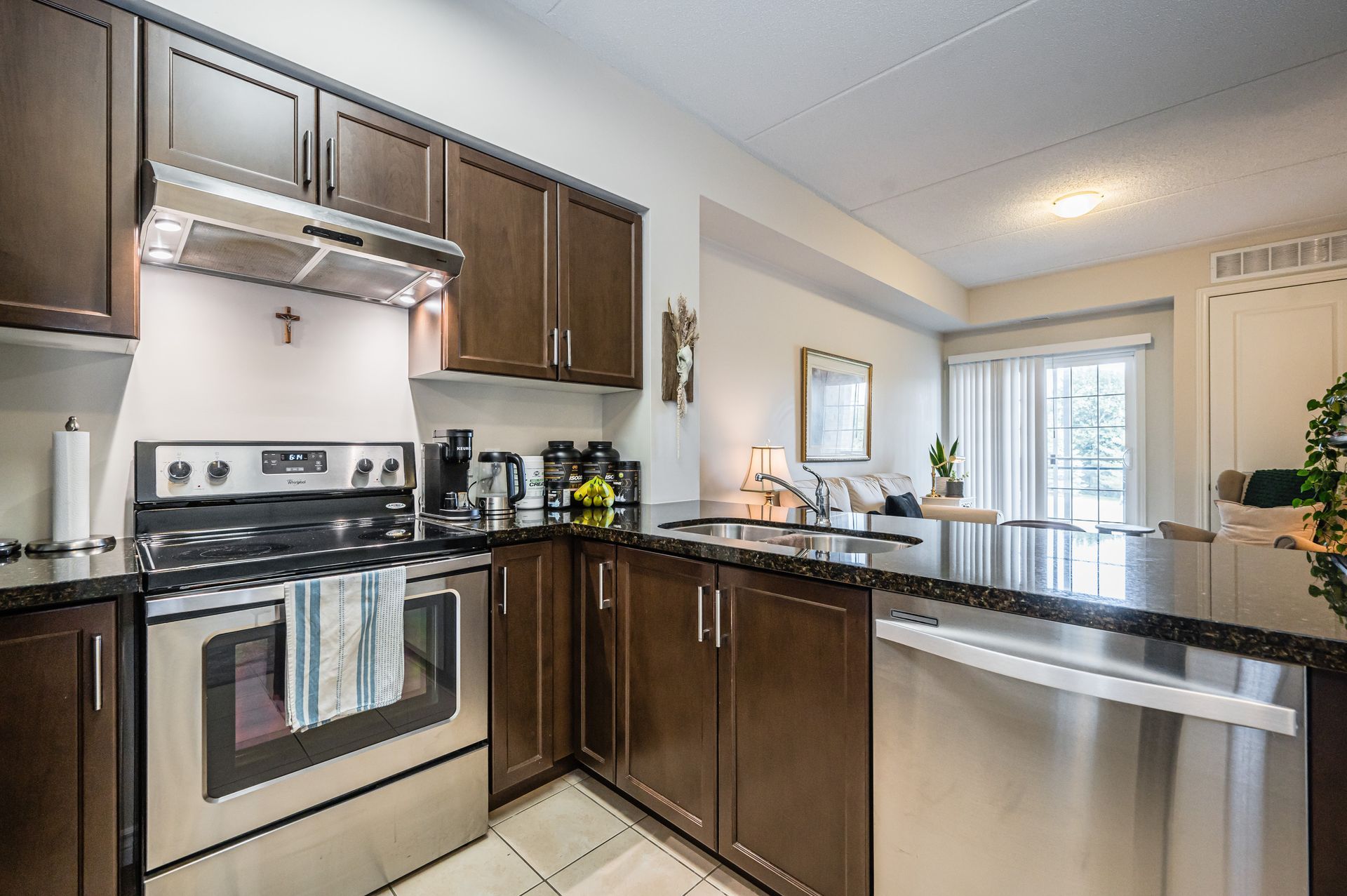 Modern kitchen with stainless steel appliances, dark cabinets, granite counters, and a breakfast bar