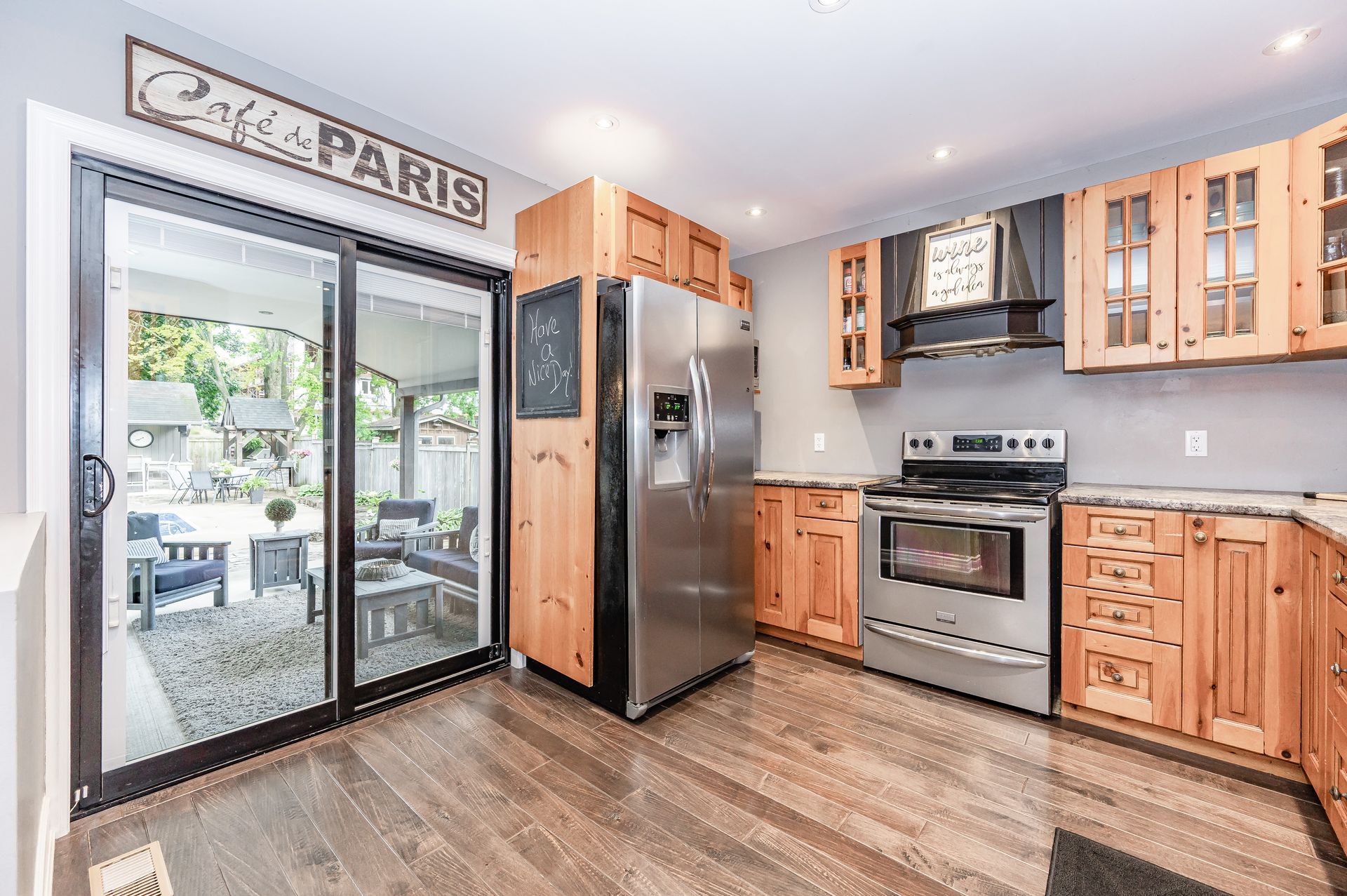 Bright modern kitchen with wood cabinets, stainless appliances, and sliding glass doors to a patio