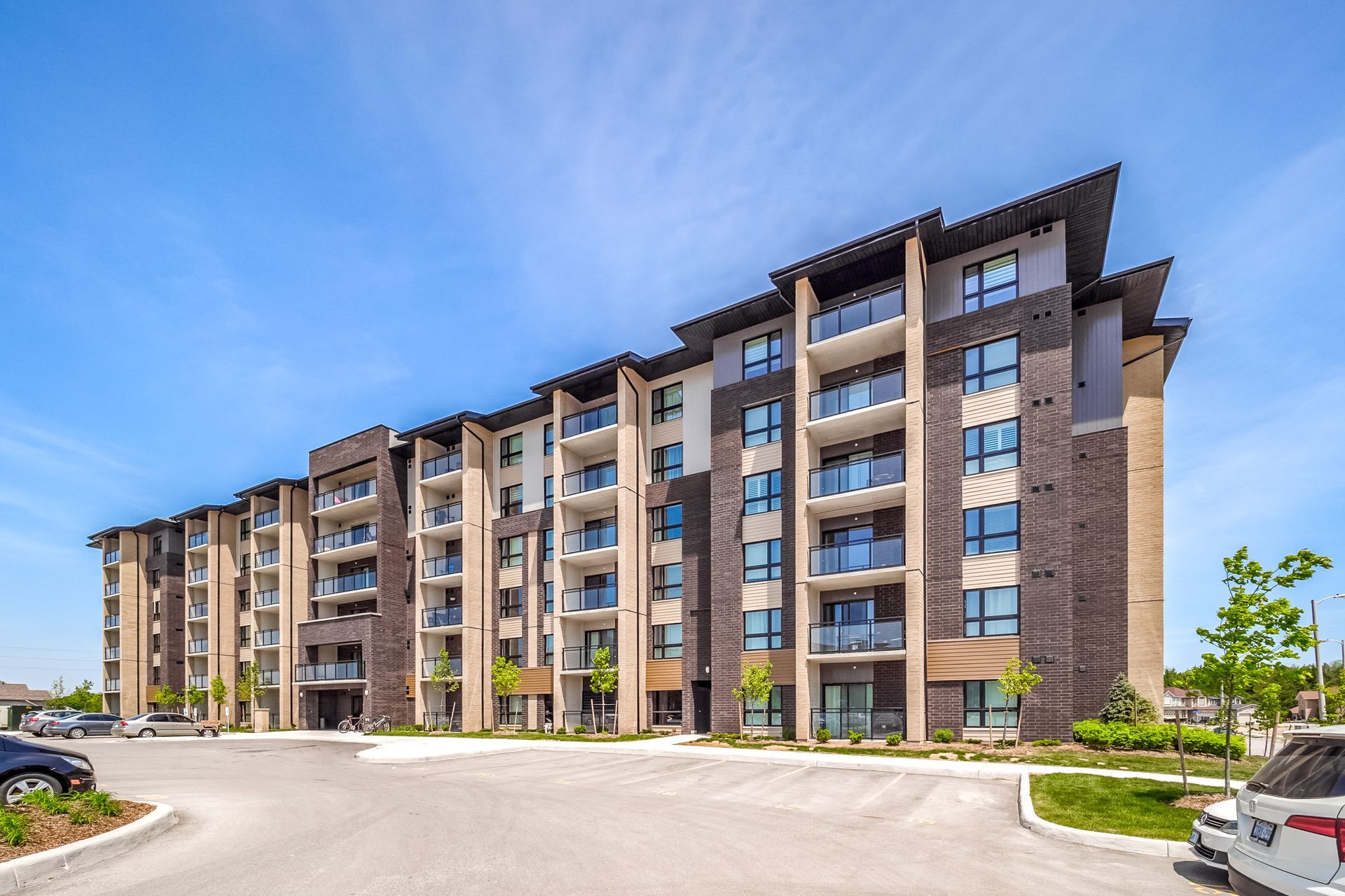 Modern apartment building with brick and glass facade under a blue sky