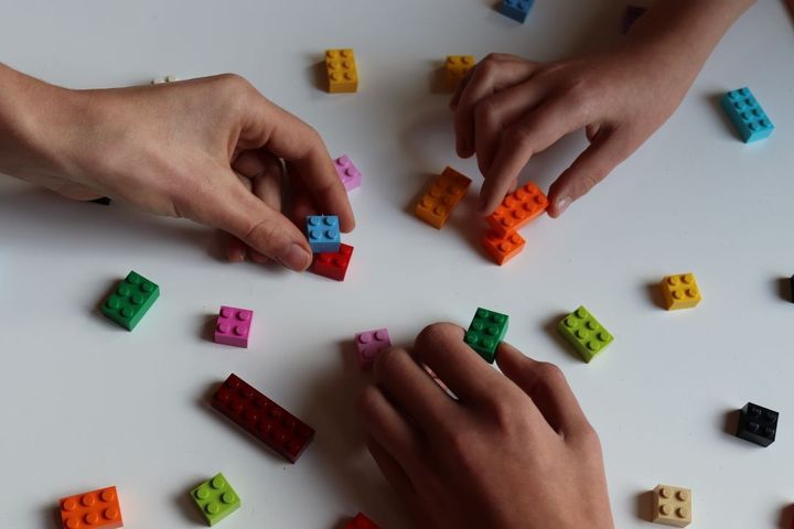 handen metlegoblokjes op een tafel