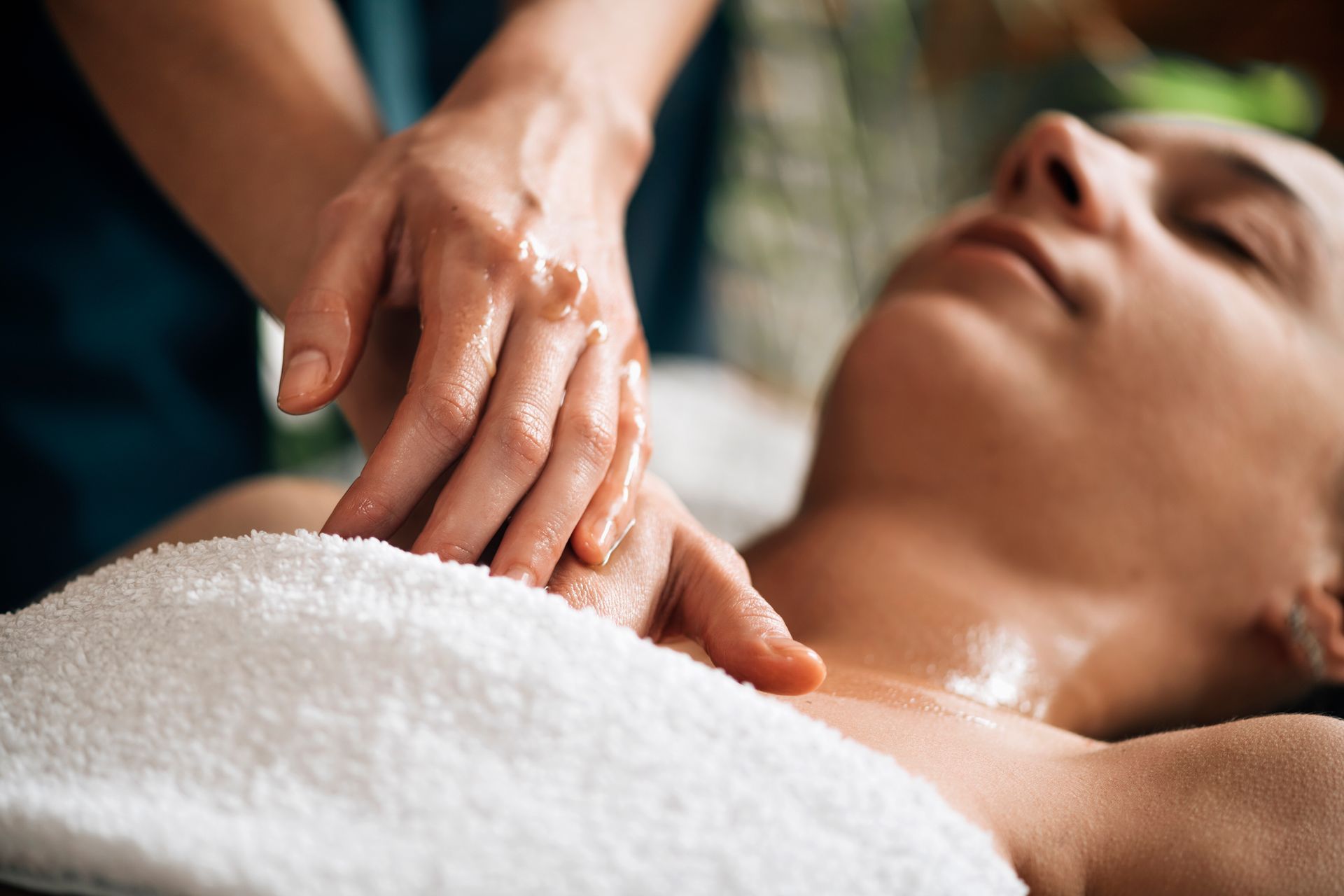 Hands gently massaging a person’s face during a spa treatment