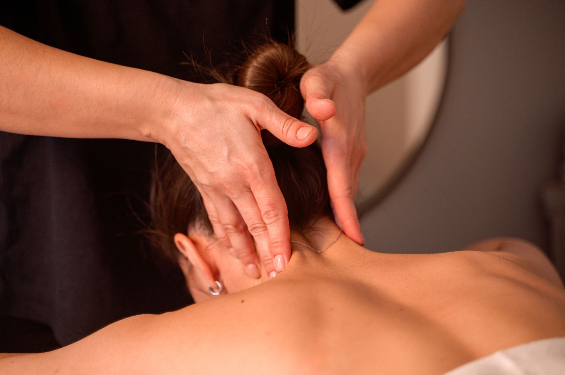 Shoulder massage in a warm softly lit treatment room