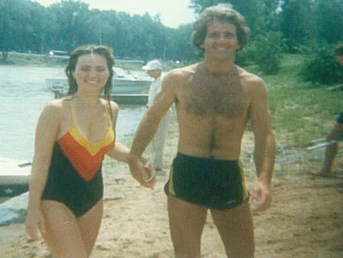 A man and a woman are holding hands on the beach.