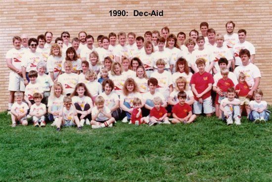 A large group of people are posing for a picture in front of a brick wall.
